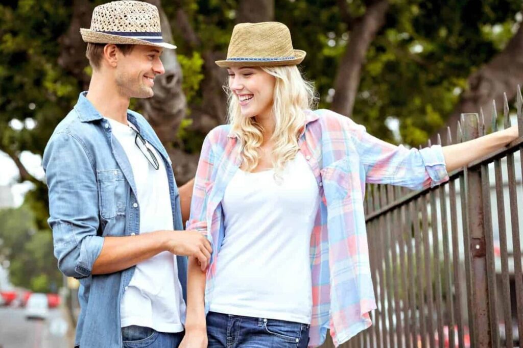 Cómo vencer el miedo al rechazo y conquistar a una mujer bonita 1 imagen de portada un hombre sonriente acercandose a una mujer bonita en un entorno amigable y relajado