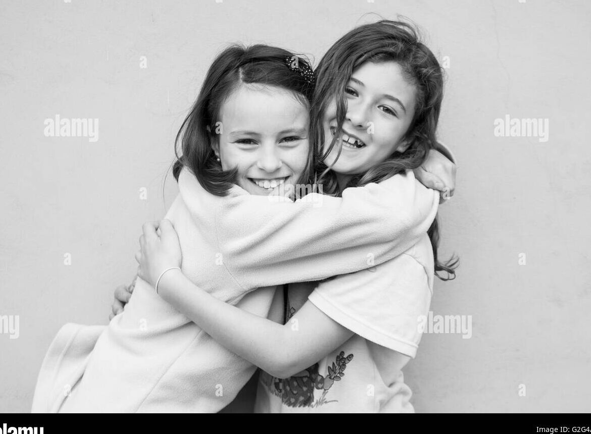 una foto en blanco y negro de dos hermanas sonriendo y abrazandose