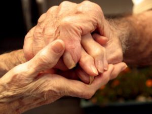 Carta de despedida temporal: Amor y esperanza en cada palabra 5 una imagen de dos manos entrelazadas con una carta de despedida escrita sobre una mesa