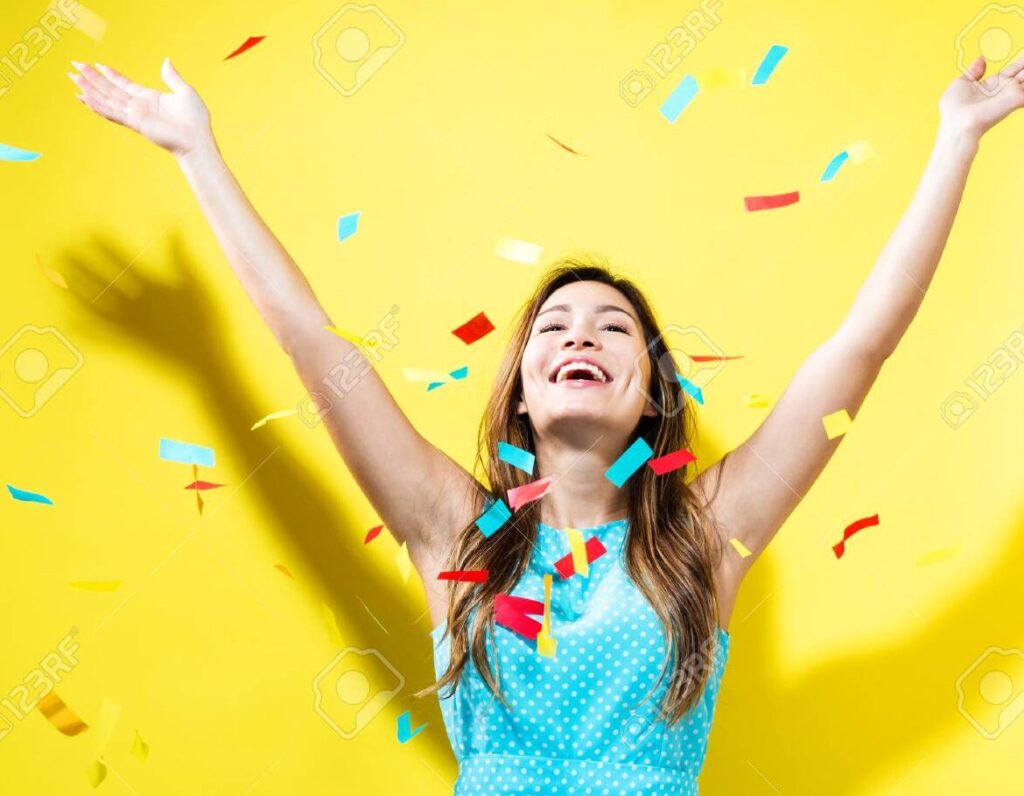 Frases de felicitaciones por tus logros: inspira y celebra tus éxitos 1 una imagen de fondo con colores vibrantes confeti y una persona sonriendo y levantando los brazos en senal de celebracion