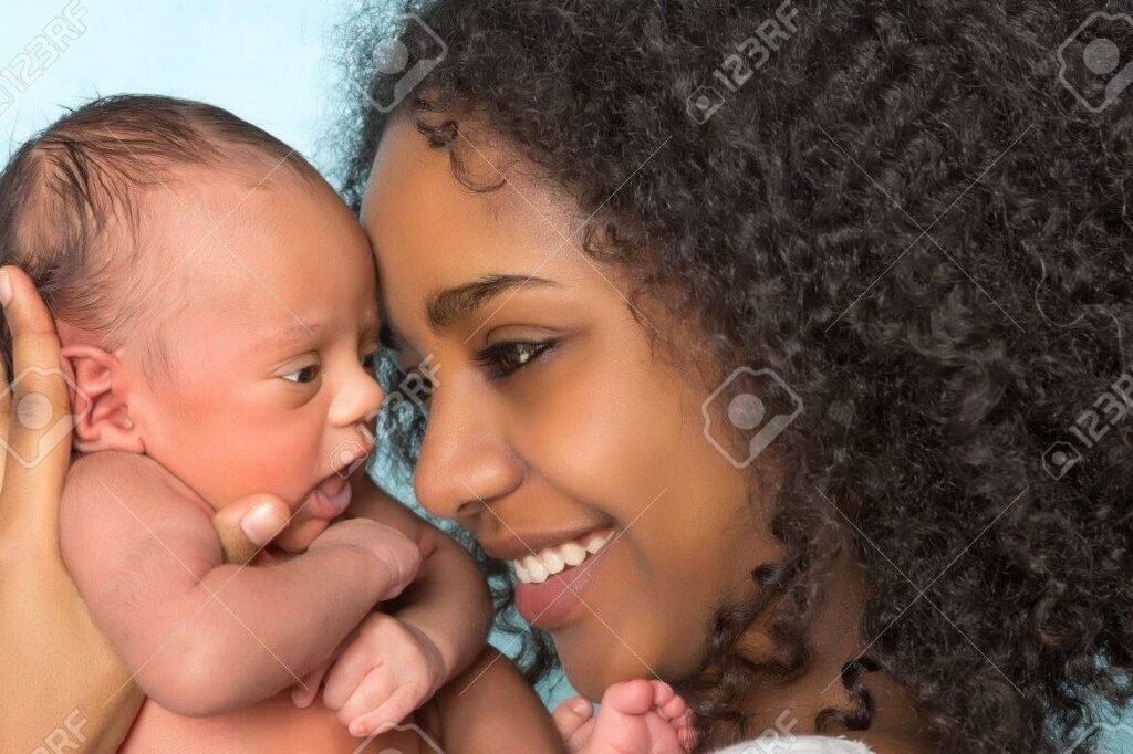 10 formas de felicitar a una nueva mamá y hacerla sentir especial 1 una imagen de una madre sonriente sosteniendo a su bebe recien nacido