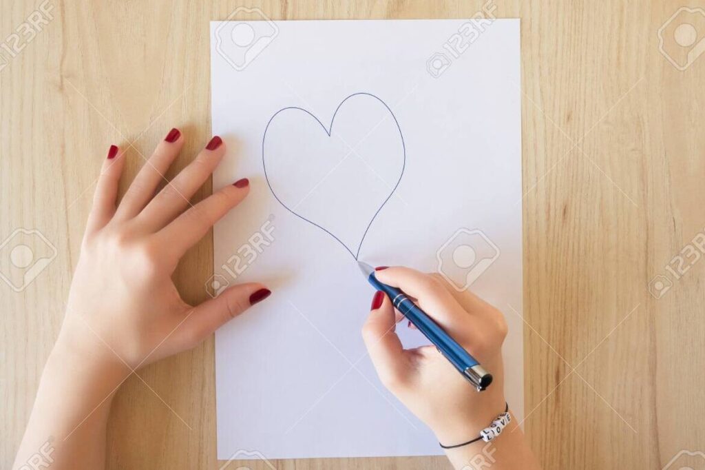 Despierta emociones con una carta de amor que haga latir tu corazón 1 una imagen de una mano escribiendo una carta de amor con un corazon dibujado en el papel