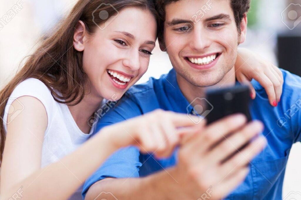 Recupera a tu ex con mensajes de WhatsApp: Estrategias efectivas 1 una imagen de una pareja sonriente mirando sus telefonos moviles mientras envian mensajes de whatsapp