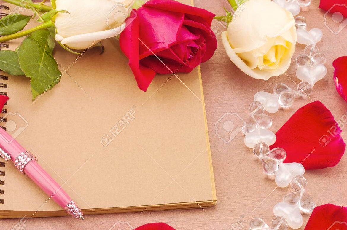 una imagen romantica con una pluma y un papel rodeados de petalos de rosas rojas