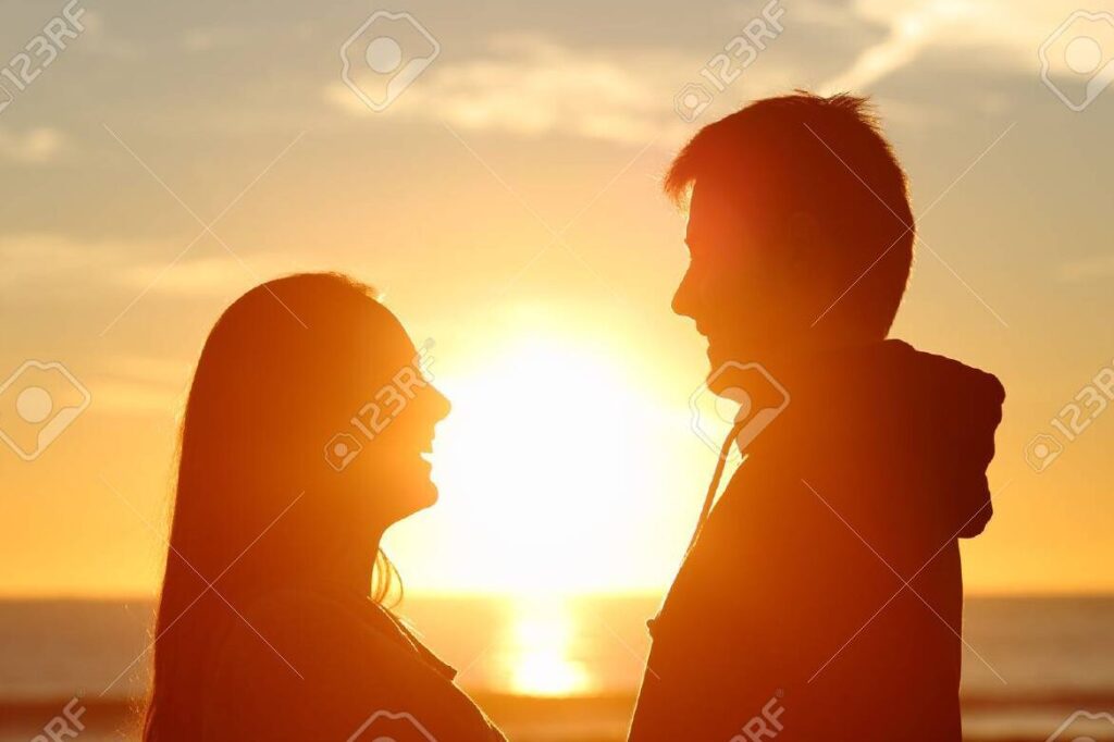 Descubre cómo expresar tu amor a una mujer con un poema inolvidable 1 una pareja abrazada en el atardecer mirandose con ternura mientras el sol se pone en el horizonte