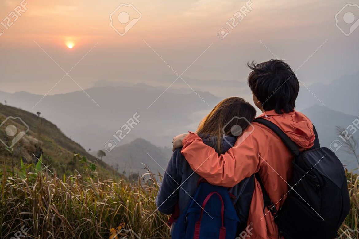 una pareja abrazada en un hermoso paisaje al atardecer