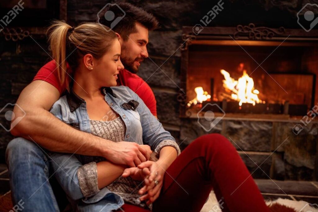 Frases de amor que calientan corazones en el frío 1 una pareja abrazandose frente a una chimenea encendida