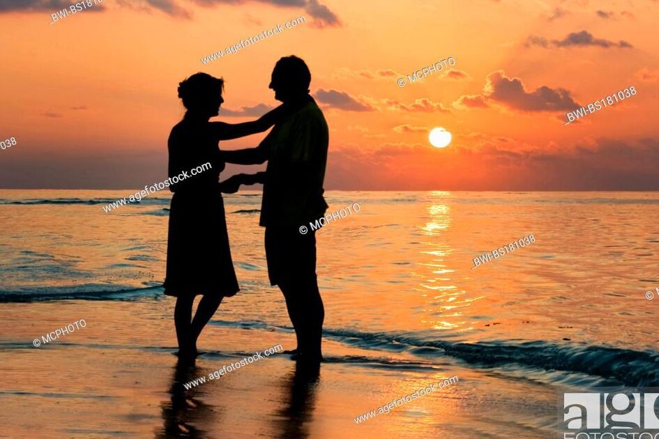 una pareja de jovenes abrazados frente a un atardecer en la playa