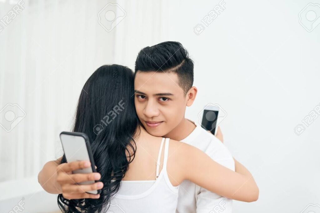 Cómo pedirle que sea mi novia de forma original por WhatsApp 1 una pareja sonriendo y mirando sus telefonos mientras envian mensajes de texto