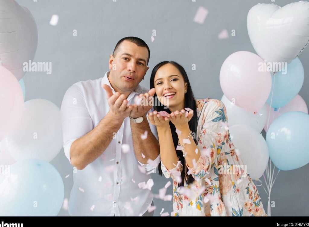 Celebrando 5 meses de amor y felicidad juntos: cómo expresarlo 1 una pareja sonriente abrazada en un parque con globos de colores y confeti en el aire
