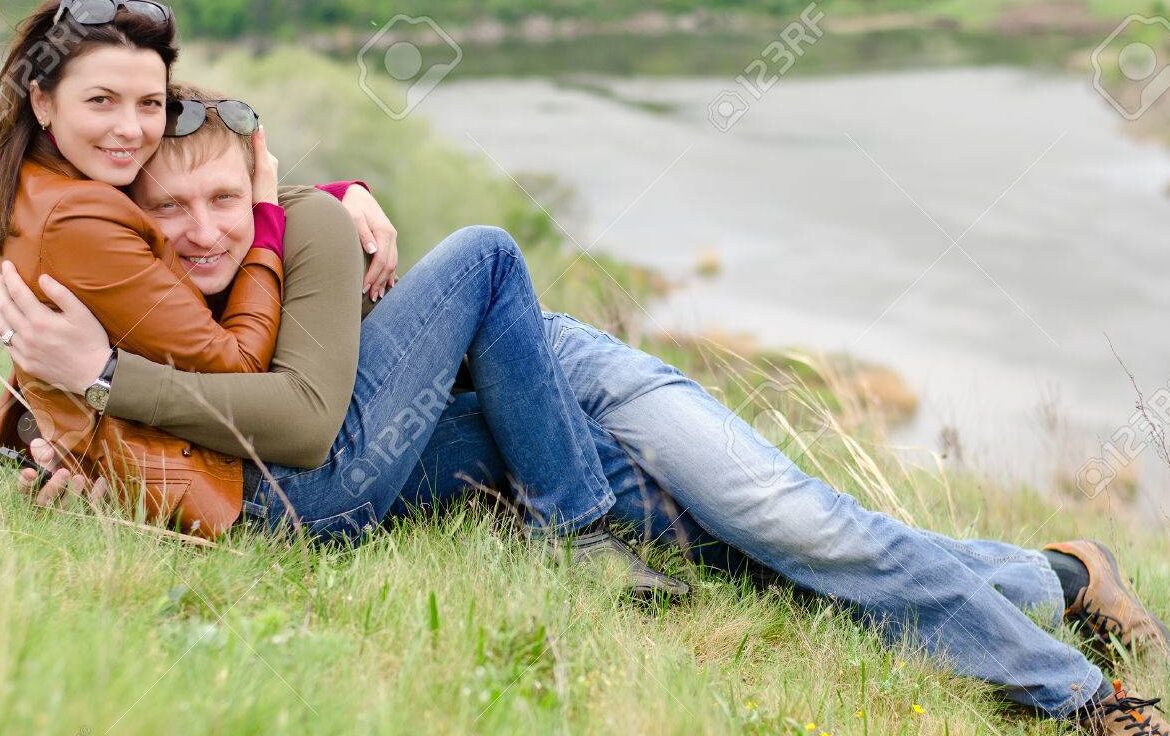 una pareja sonriente abrazandose en un paisaje romantico