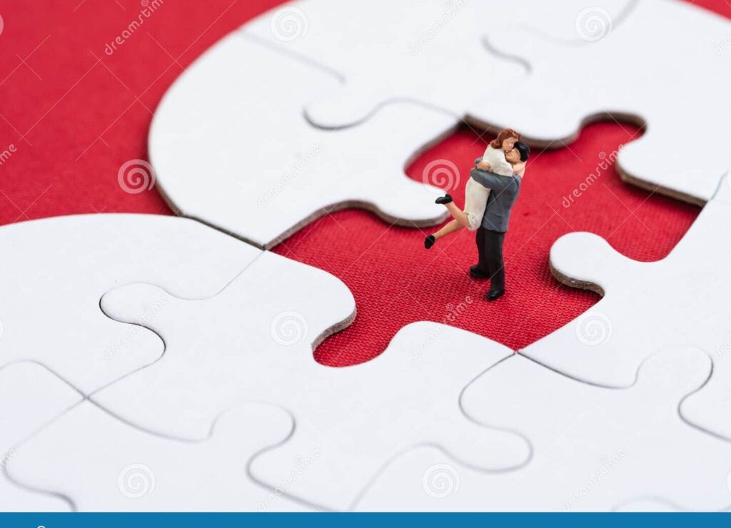 una pareja sosteniendo un rompecabezas con una pieza faltante en forma de corazon